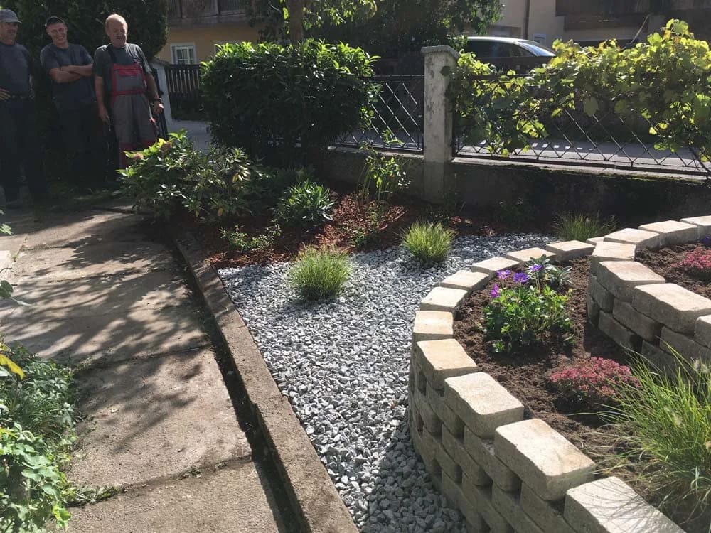 Blumenbeet mit Steinen und kleinen grünen Pflanzen